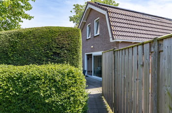 Zijkant van het huis met haag en pad